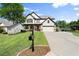Well-maintained two-story home with a green lawn, a lovely garden, and an attached garage at 6235 Crescent Landing Dr, Cumming, GA 30028