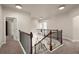 Upstairs hallway with carpeted flooring and dark wood railing overlooking the living room at 6235 Crescent Landing Dr, Cumming, GA 30028