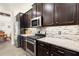 Well-equipped kitchen with granite countertops, stainless steel appliances, and dark wood cabinets at 6235 Crescent Landing Dr, Cumming, GA 30028