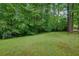 Spacious backyard with lush green lawn and mature trees, offering privacy and plenty of outdoor living space at 4373 Mikandy Nw Dr, Kennesaw, GA 30144