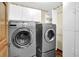 Laundry room features front loading washer and dryer, utility closet and built in storage, plus wood flooring at 4373 Mikandy Nw Dr, Kennesaw, GA 30144