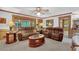 Open living room with brown reclining sofas, built-in wood trim, and access to kitchen at 4373 Mikandy Nw Dr, Kennesaw, GA 30144