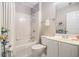 A bright bathroom features a shower and tub combo, white tile, and a vanity with a mirror at 5004 Lake Mist Se Dr, Smyrna, GA 30126
