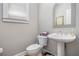 Stylish powder room featuring a pedestal sink, toilet, and decorative mirror at 5004 Lake Mist Se Dr, Smyrna, GA 30126