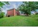 Spacious backyard with well-manicured lawn, brick house, and mature shade trees at 5610 Mountain Meadow Ct, Stone Mountain, GA 30087