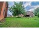 Large backyard with lush green lawn, brick house, and mature trees at 5610 Mountain Meadow Ct, Stone Mountain, GA 30087