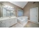 Bathroom featuring a soaking tub, double sink vanity, tile floors, and walk-in shower at 5610 Mountain Meadow Ct, Stone Mountain, GA 30087