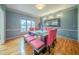 Formal dining room featuring gray walls, trim detail, modern lighting, and natural light from large window at 5610 Mountain Meadow Ct, Stone Mountain, GA 30087