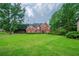 Spacious brick home featuring a well-maintained lawn and mature trees at 5610 Mountain Meadow Ct, Stone Mountain, GA 30087