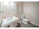 Compact powder room featuring a pedestal sink, stylish wallpaper, and modern fixtures at 5610 Mountain Meadow Ct, Stone Mountain, GA 30087