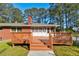 Back of a brick house with a wood deck and large backyard with mature trees at , Mableton, GA 30126