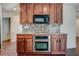 Kitchen featuring stainless steel oven, microwave, and dark wood cabinets with mosaic backsplash at , Mableton, GA 30126
