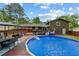 Enjoy outdoor living with this backyard featuring an in-ground pool, large deck, and mature trees at 173 Avalon Way, Riverdale, GA 30274
