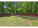 Fenced backyard offers a fire pit and swing set for relaxing and outdoor entertainment at 173 Avalon Way, Riverdale, GA 30274
