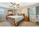 A well-lit bedroom features a large bed, wood furniture, neutral walls, carpet, and a ceiling fan at 173 Avalon Way, Riverdale, GA 30274