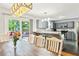 Open-concept layout with a dining table that connects to a modern kitchen and scenic outdoor views at 173 Avalon Way, Riverdale, GA 30274