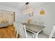 Dining room with seating for six adjacent to living room; features decorative lighting and hardwood floors at 173 Avalon Way, Riverdale, GA 30274