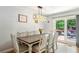Cozy dining area with a modern light fixture, seating for eight, and sliding door access to outdoor deck at 173 Avalon Way, Riverdale, GA 30274