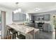 Well-lit kitchen featuring gray cabinets, a breakfast bar with seating, and modern stainless steel appliances at 173 Avalon Way, Riverdale, GA 30274