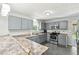 Bright kitchen features gray cabinets, stainless steel appliances, and functional countertops with a breakfast bar at 173 Avalon Way, Riverdale, GA 30274