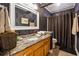 Stylish bathroom with a granite countertop, patterned wallpaper, and a shower with a curtain at 1820 Habersham Gate Dr, Cumming, GA 30041