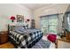Charming bedroom featuring a large window, wood floors, and a comfortable bed with stylish black and white bedding at 1820 Habersham Gate Dr, Cumming, GA 30041