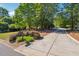 Paved driveway leading to a well-maintained home with lush landscaping and mature trees at 1820 Habersham Gate Dr, Cumming, GA 30041