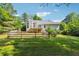 Rear exterior view of house with deck, walkout basement, fenced in backyard and wooded backdrop at 1820 Habersham Gate Dr, Cumming, GA 30041