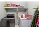 Functional laundry room with modern washer, dryer, overhead storage, and ironing board at 1820 Habersham Gate Dr, Cumming, GA 30041