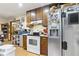 View of kitchen with stove, stainless fridge, microwave, wooden cabinets and laminate floor at 4720 Bill Cheek Rd, Auburn, GA 30011