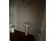 Compact half-bathroom featuring pedestal sink, toilet, and hardwood-style flooring at 545 Tulip Ln, Mcdonough, GA 30252