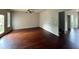 Expansive living room with gleaming hardwood floors, ceiling fan, and natural light from door at 545 Tulip Ln, Mcdonough, GA 30252