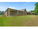 Spacious backyard featuring a covered patio, lush green lawn, and view of the home's exterior at 6805 Bransford Dr, Cumming, GA 30040