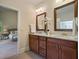 Bathroom with double vanity, wood cabinets, granite counters, and access to main bedroom at 6805 Bransford Dr, Cumming, GA 30040