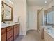 Bathroom featuring double vanity, walk-in shower, and soaking tub at 6805 Bransford Dr, Cumming, GA 30040