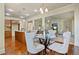 Cozy dining area with hardwood floors, chandelier, and views into the kitchen and living room, perfect for meals at 6805 Bransford Dr, Cumming, GA 30040