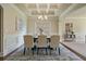 Elegant dining room featuring coffered ceilings, wainscoting, a modern chandelier, and seating for six at 6805 Bransford Dr, Cumming, GA 30040
