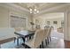 Elegant dining room features decorative molding, tray ceiling, hardwood floors, and access to a formal office at 6805 Bransford Dr, Cumming, GA 30040