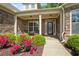 Inviting front porch with stone accents, colorful landscaping, and comfortable seating area, creating curb appeal at 6805 Bransford Dr, Cumming, GA 30040