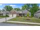 Charming home with brick exterior, well-manicured lawn, colorful flowerbeds, and a two-car garage at 6805 Bransford Dr, Cumming, GA 30040