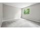 A carpeted bedroom has gray walls and a window that provides natural light at 9438 Cedar Creek Pl, Douglasville, GA 30135