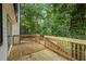 A wooden deck features wood railings and is partially shaded by mature trees at 9438 Cedar Creek Pl, Douglasville, GA 30135