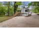 Home exterior showcases driveway, garage, deck, and yard with mature trees at 9438 Cedar Creek Pl, Douglasville, GA 30135