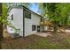 Back exterior of home with yard, deck, sliding glass doors and white siding at 9438 Cedar Creek Pl, Douglasville, GA 30135