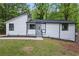 Charming renovated home featuring black trim, white siding, and a well-manicured front lawn at 9438 Cedar Creek Pl, Douglasville, GA 30135