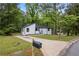 Charming home with a modern design, landscaped yard, and a spacious driveway nestled among mature trees at 9438 Cedar Creek Pl, Douglasville, GA 30135