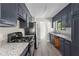 Renovated kitchen boasts granite counters, gray cabinets, and stainless steel appliances at 9438 Cedar Creek Pl, Douglasville, GA 30135
