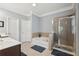 Bathroom featuring garden tub, tiled shower, and vanity with white countertops at 1840 Brighton Se Blvd, Atlanta, GA 30316