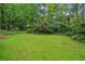 Expansive backyard with lush green lawn and mature trees for a serene outdoor retreat at 2700 Regency E Dr, Tucker, GA 30084