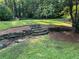 Beautiful backyard featuring stone steps, mature trees, and lush green lawn at 2700 Regency E Dr, Tucker, GA 30084
